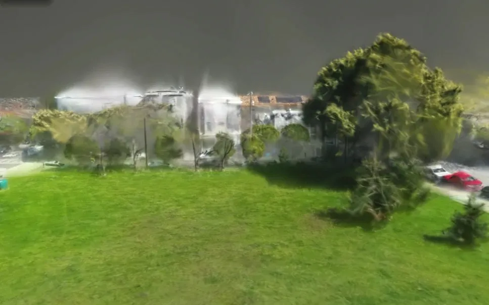 Gaussian splat render of Duboce Park at eye level, with sharp grass in the foreground and houses and trees dissolving into translucent streaks